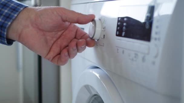 管家使用洗衣机设定程序并按下启动按钮 — 图库视频影像