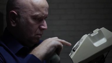 Sinirli ve yorgun iş adamı geç saatlere kadar çalışıyor Eski Teknoloji Telefonunu kullanarak bir telefon görüşmesi yap.