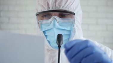 Korunma giysisi giyen ve Coronavirüs salgını hakkında konuşan bir doktorla Yavaş Hareket