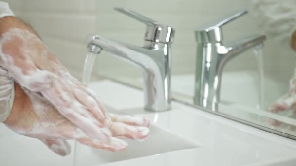 Mouvement lent avec l'homme dans les toilettes Lavant avec du savon et de l'eau Nettoyant et désinfectant ses mains contre les virus — Video