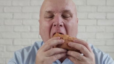 Aç Kişi Lezzetli Hamburger yer, Parmaklarını Birleştirir Fast Food Lokantasında Lezzetli Atıştırmalıkların Tadını Çıkarır