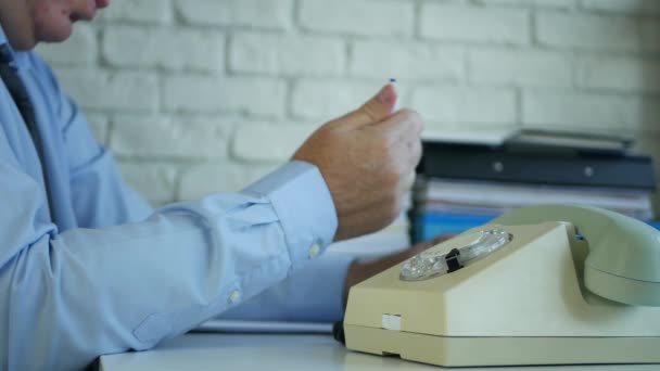 Persona de edad avanzada que espera impaciente una llamada telefónica que sugiere nerviosismo con una pluma — Vídeo de stock