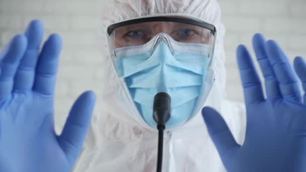 Spécialiste médical portant un costume de protection et parlant dans une conférence de presse médicale à propos de l'épidémie de coronavirus — Video