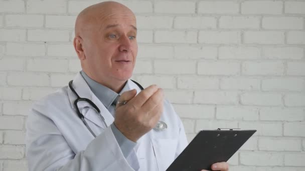 Moción lenta con un médico sonriendo y escribiendo una receta médica para una cura de vitaminas — Vídeos de Stock