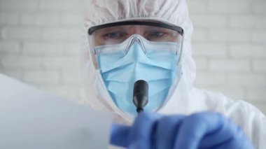 Korunma giysisi giyen ve Coronavirüs salgını hakkında bir tıbbi basın toplantısında konuşan Tıbbi Uzmanla Yavaş Hareket