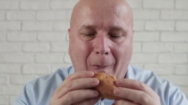 Aç Kişi Lezzetli Hamburger yer, Parmaklarını Birleştirir Fast Food Lokantasında Lezzetli Atıştırmalıkların Tadını Çıkarır