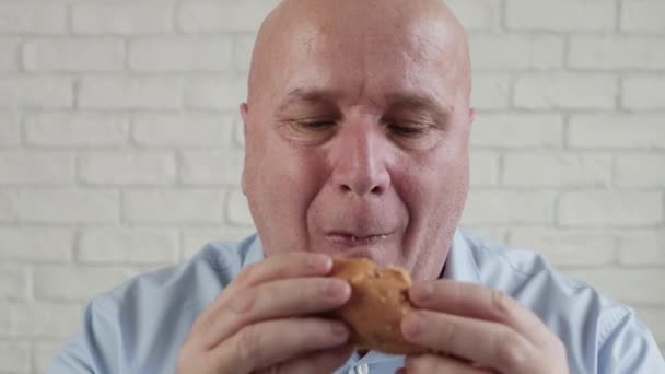 おいしいハンバーガーを食べ、指をリンクさせる飢餓者は、ファーストフードレストランでおいしいスナックを楽しむ — ストック動画