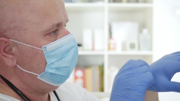 Imagen del médico con máscara facial protectora y guantes, persona médica con equipo de protección en un hospital en cuarentena contra la epidemia de virus — Vídeos de Stock