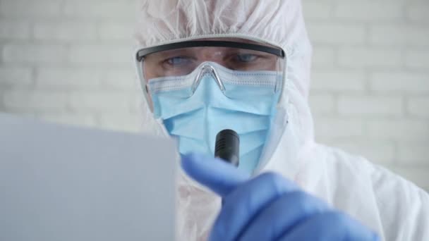 Врач в защитном костюме и на медицинской пресс-конференции об эпидемии коронавируса — стоковое видео