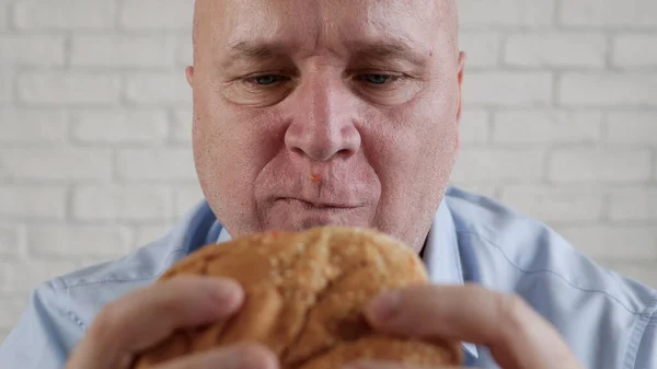 Голодный человек, поедающий вкусный гамбургер, наслаждается вкусной закуской в ресторане быстрого питания — стоковое фото