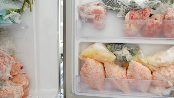 Freezer Filled with Meat and Vegetable Packets Frozen in Plastic Bags Food Reserve Stored for Food Preparation