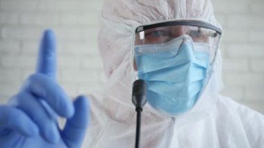 Korunma giysisi giyen ve Coronavirüs salgını hakkında konuşan bir Şifacı ile Yavaş Hareket