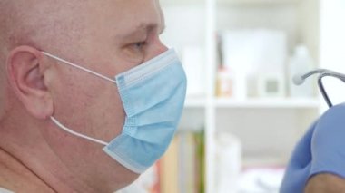 Koruyucu yüz maskesi, eldiven ve stetoskop takan doktor, Virüs salgınına karşı karantinada korunan bir hastanede tıbbi ekipman.