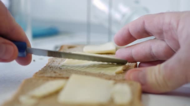 Colazione mattutina con burro sul pane tostato, diffusione di margarina su una fetta di pane fresco in cucina — Video Stock