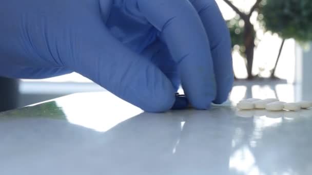 Slow Motion Doctor handen dragen van beschermende handschoenen Selecteren van medische pillen voor een behandeling in het ziekenhuis — Stockvideo