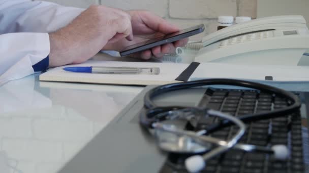 Arzt im Krankenhaus sendet SMS per Handy-Netzwerk-Kommunikation, Arzt sendet eine Nachricht auf dem Handy aus dem medizinischen Kabinett — Stockvideo