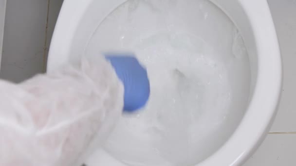 Person Bär Skydd Kläder Desinficera Toalett skål i badrum, Städning av insidan av en toalett skål med desinfektionsmedel — Stockvideo