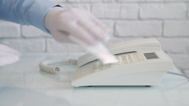 Slow Motion with a Man Wearing Protection Gloves in Hands Cleaning and Disinfecting a Telephone Using a Spray and Wet Wipes — Stock Video