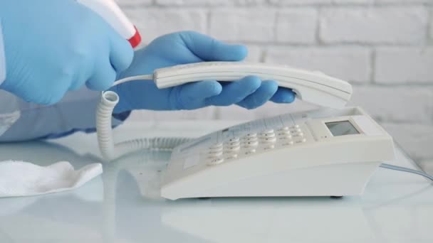 Slow Motion met een man die handschoenen draagt in handen reinigen en desinfecteren van een telefoon met behulp van een spray en natte doekjes — Stockvideo