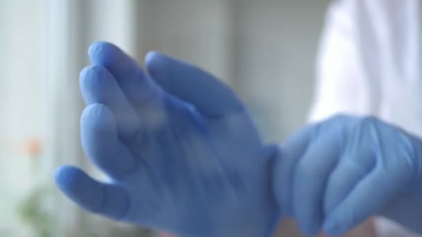 Doctor zet zijn hand beschermd met een handschoen op venster oppervlak in een quarantaine kamer — Stockvideo