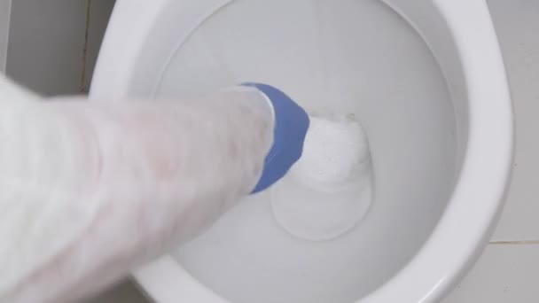 Лицо с защитой от ношения Одежда для дезинфекции унитаза в ванной комнате, уборка интерьера унитаза дезинфицирующим средством — стоковое видео