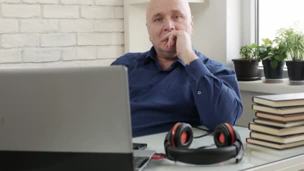 Homme travaillant à domicile connecté à un appel vidéo à l'aide d'une webcam et d'écouteurs pour ordinateur portable, distanciation sociale lors d'une pandémie de Covid-19, télétravail à domicile — Video