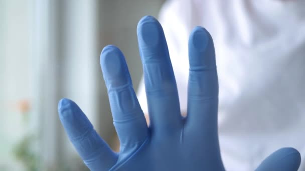Доктор кладет руку под защиту перчаткой на поверхность окна в карантинной комнате — стоковое видео