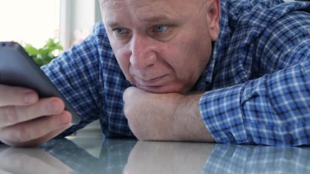 Triste persona mayor aislada en cuarentena en casa mirando aburrida y decepcionada a un teléfono celular — Vídeo de stock