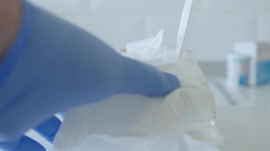 Temizlik ve dezenfekte için ıslak mendil kullanan eldivenlerle korunan eller.