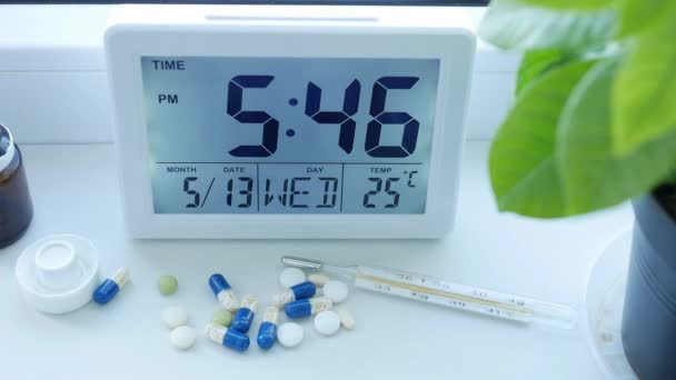 Reloj despertador en la mesa y píldoras médicas para un tratamiento en una sala de hospital — Vídeos de Stock