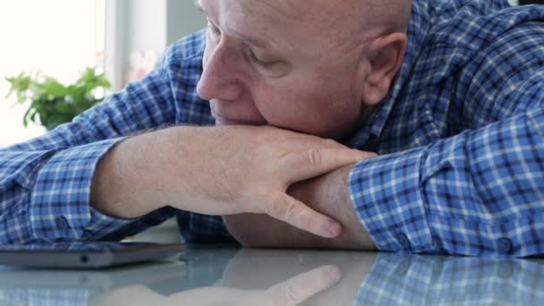 Грустный пожилой человек, изолированный в карантине дома, выглядит утомленным и разочарованным в мобильном телефоне — стоковое видео