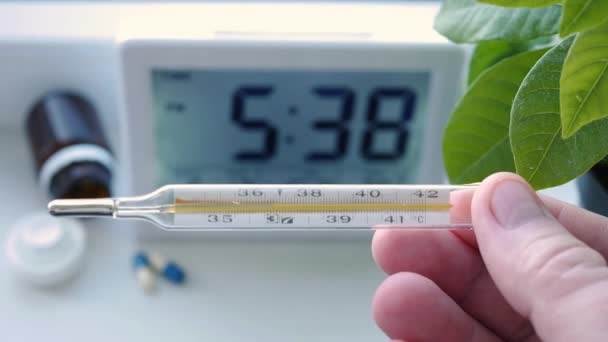 Dokter dragen van beschermende handschoenen Houd in handen een thermometer gebruikt voor het testen van de menselijke lichaamstemperatuur — Stockvideo