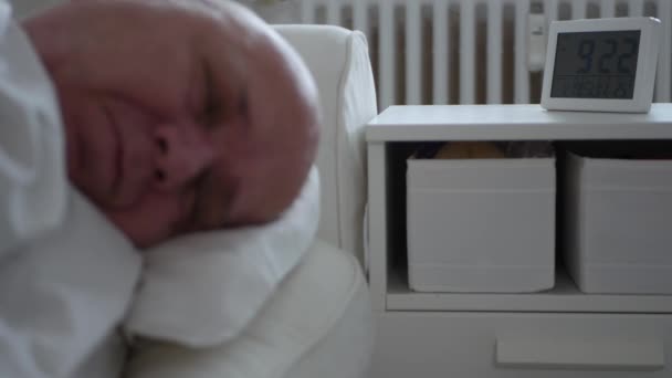 L'homme vertigineux se réveille du sommeil et déclenche l'alarme d'horloge — Video