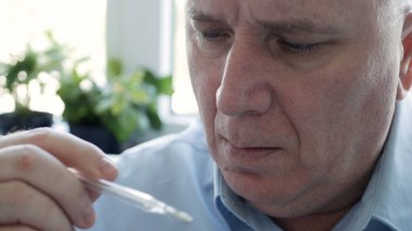 Coronavirus semptomları gösteren bir adam bir hastanede vücut ısısını ölçmek için civa ölçeğinde termometre kullanıyor.