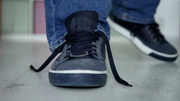 Человек, готовящийся к прогулке в развязанных шнурках на спортивной обуви — стоковое фото