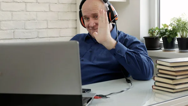 Homem trabalhando a partir de casa e falando em uma chamada de vídeo usando Laptop Webcam e fones de ouvido, o distanciamento social em Covid-19 pandemia, trabalho remoto de casa — Fotografia de Stock