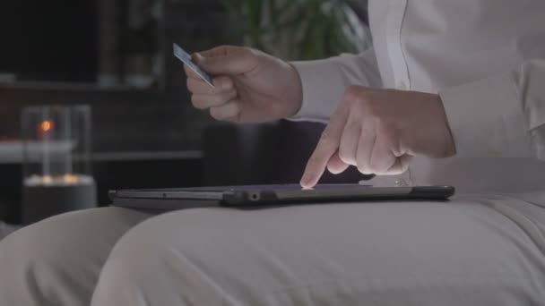 Člověk online nakupování v tabletovém počítači a zaplatí svou platební kartou — Stock video