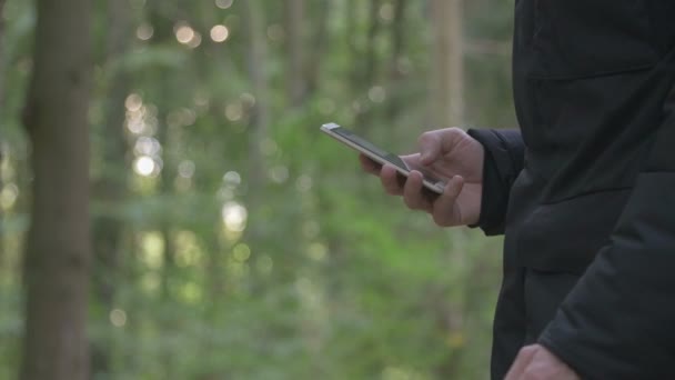 Homem escrevendo sms na floresta — Vídeo de Stock