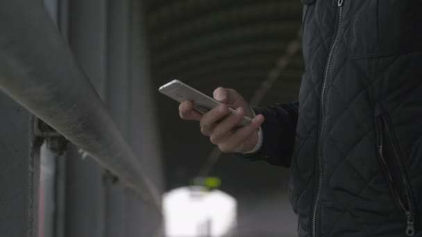 Close-up of a man using smart phone at a footbrigde — Αρχείο Βίντεο