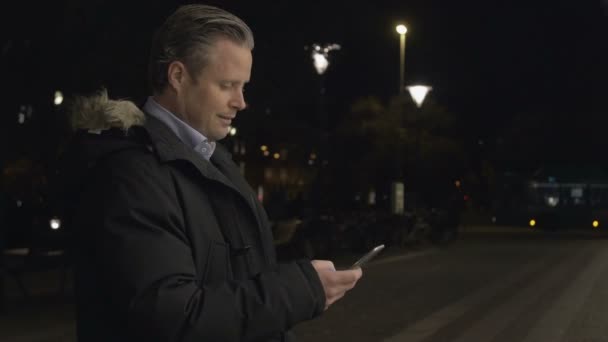 Podnikatel, použití na smartphone večer — Stock video