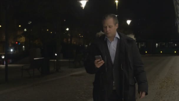 Zakenman via smartphone in de avond — Stockvideo