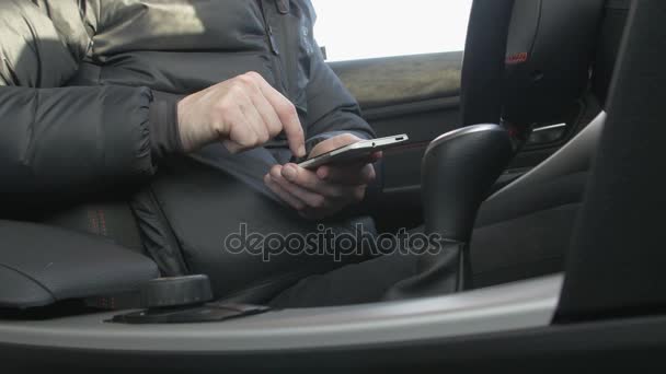 Man met behulp van een slimme telefoon in een auto — Stockvideo