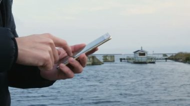 Adam bir smartphone ve sauna üzerinde tarama okyanusta yüzen