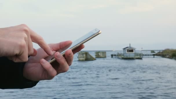 Homme tapant sur un smartphone et un sauna flotte dans l'océan — Video