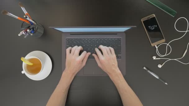 Vista superior da mesa. Homem digitando em seu laptop . — Vídeo de Stock