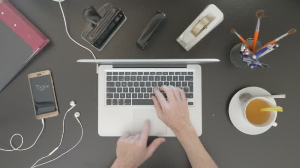 Pohled shora na stole. Muž, psaní na jeho laptopu. — Stock video