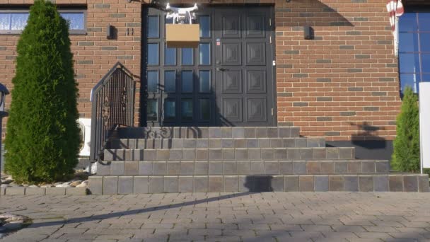 Drone consegna un pacchetto di fronte a una casa — Video Stock