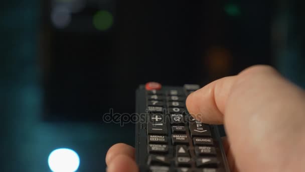 Gros plan main de l'homme tenant la télécommande TV et changer de canaux . — Video