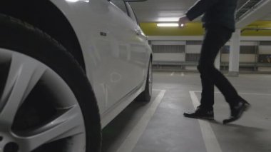 bir garajda park etmiş bir araba için adam alır