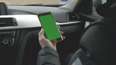 Yeşil ekran adam onun smartphone bir arabaya holding